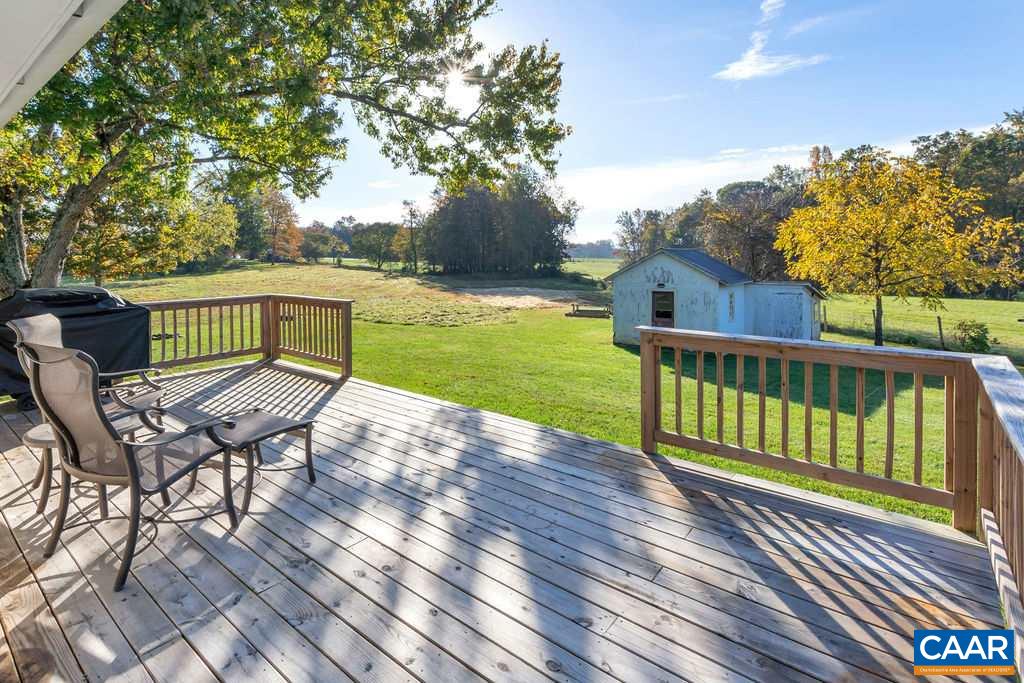 404 Blue Run Road Stanardsville, VA 22973 - Photo 12 of 43 a view of a deck with a table and chairs with wooden floor and fence