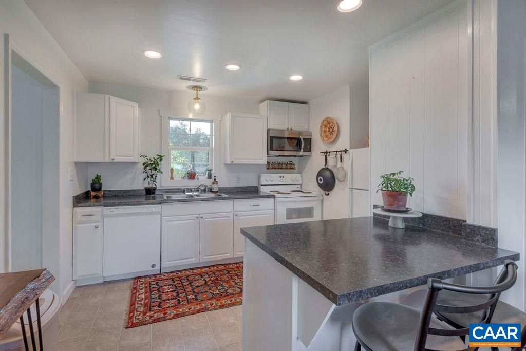 404 Blue Run Road Stanardsville, VA 22973 - Photo 25 of 43 a kitchen with stainless steel appliances granite countertop a sink counter space and living room view