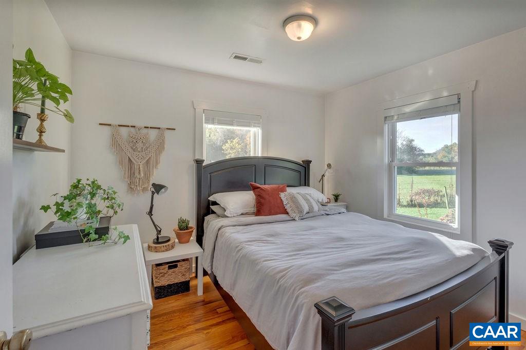 404 Blue Run Road Stanardsville, VA 22973 - Photo 34 of 43 a bedroom with a bed and a potted plant
