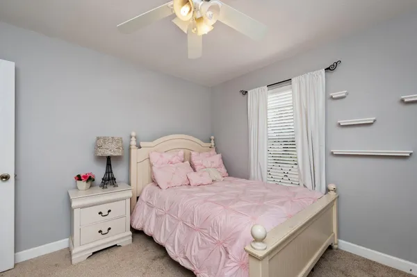 a spacious bedroom with a bed and a chandelier