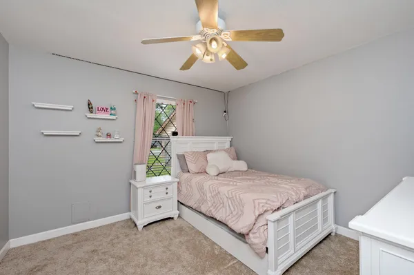 a bedroom with a large bed and a chandelier