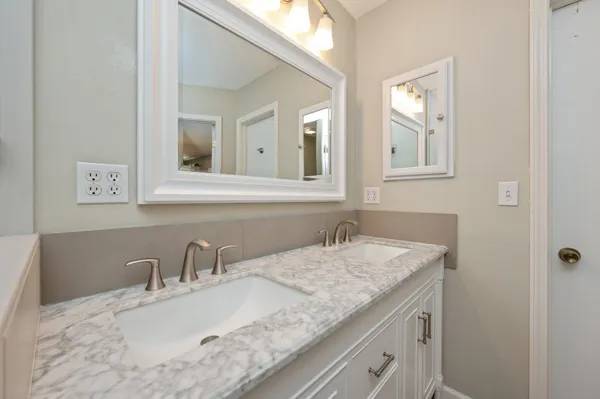 a bathroom with a granite countertop sink and a mirror