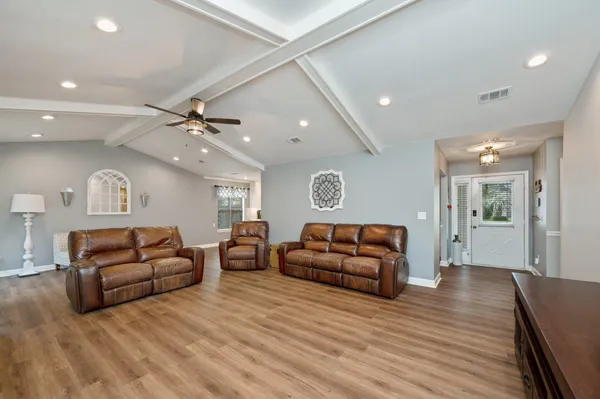 a living room with furniture and a wooden floor