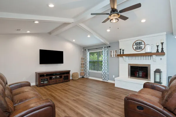 a living room with furniture a flat screen tv and a fireplace