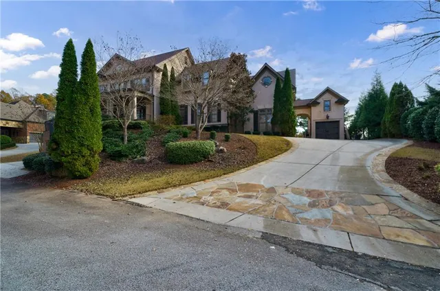 a view of a house with a yard and potted plants