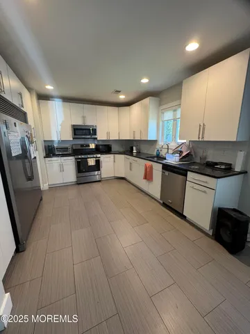 a kitchen with stainless steel appliances wooden cabinets a sink and a stove