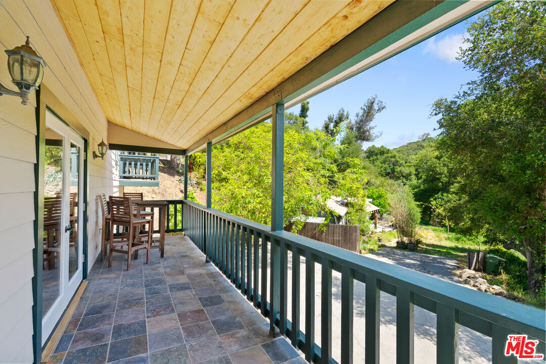 20912 Fontaine Road Topanga, CA 90290 - Photo 16 of 52 a view of a chairs and table in patio with wooden fence