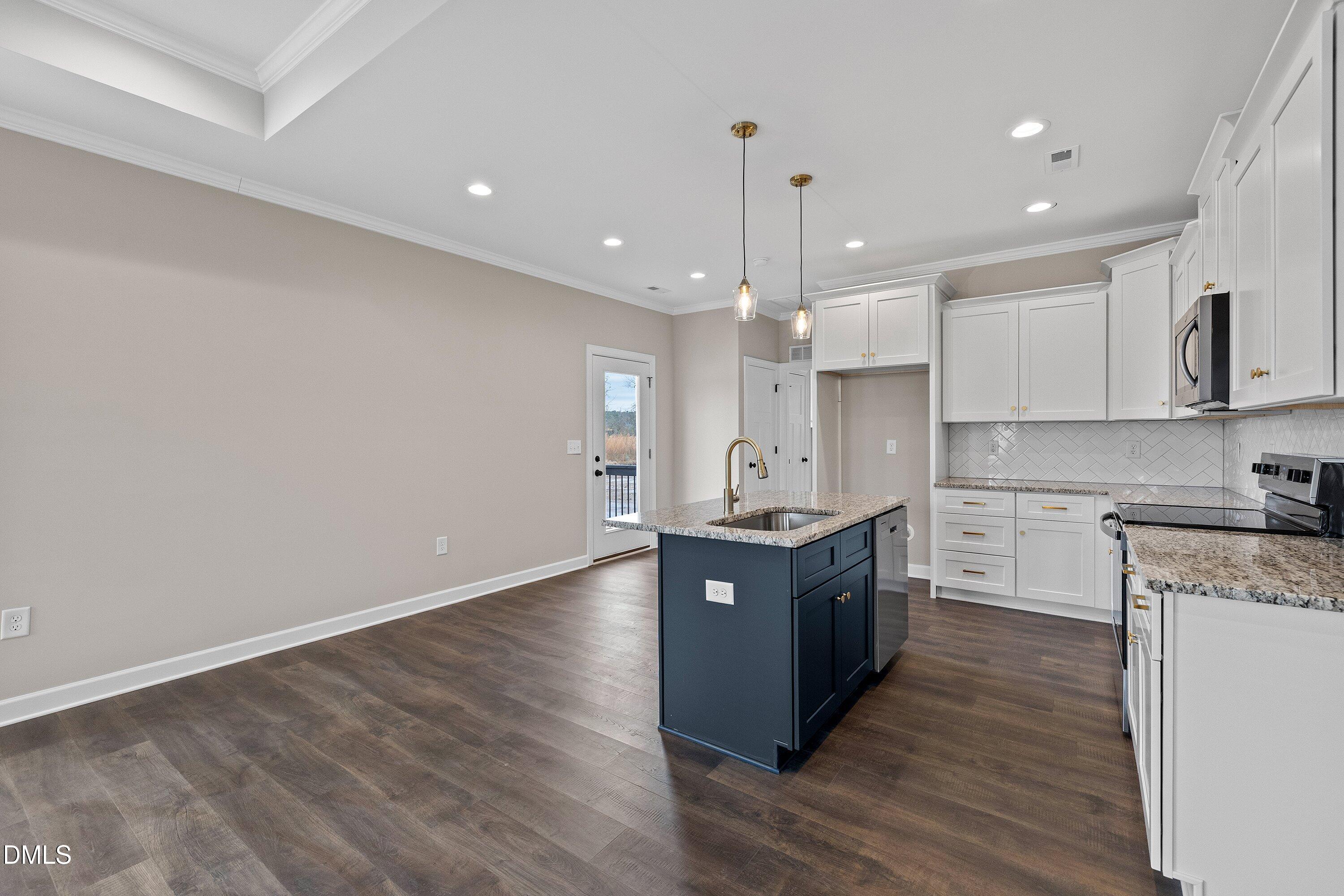 920 Micro Road West Selma, NC 27576 - Photo 12 of 34 a large kitchen with granite countertop a large counter top a sink stainless steel appliances and cabinets