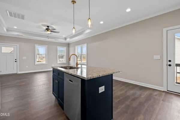 a view of an empty room and chandelier fan