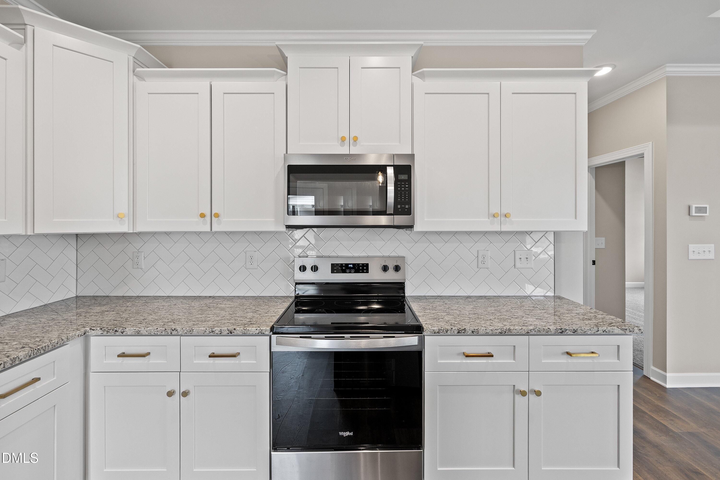 920 Micro Road West Selma, NC 27576 - Photo 19 of 34 a kitchen with granite countertop white cabinets and stainless steel appliances