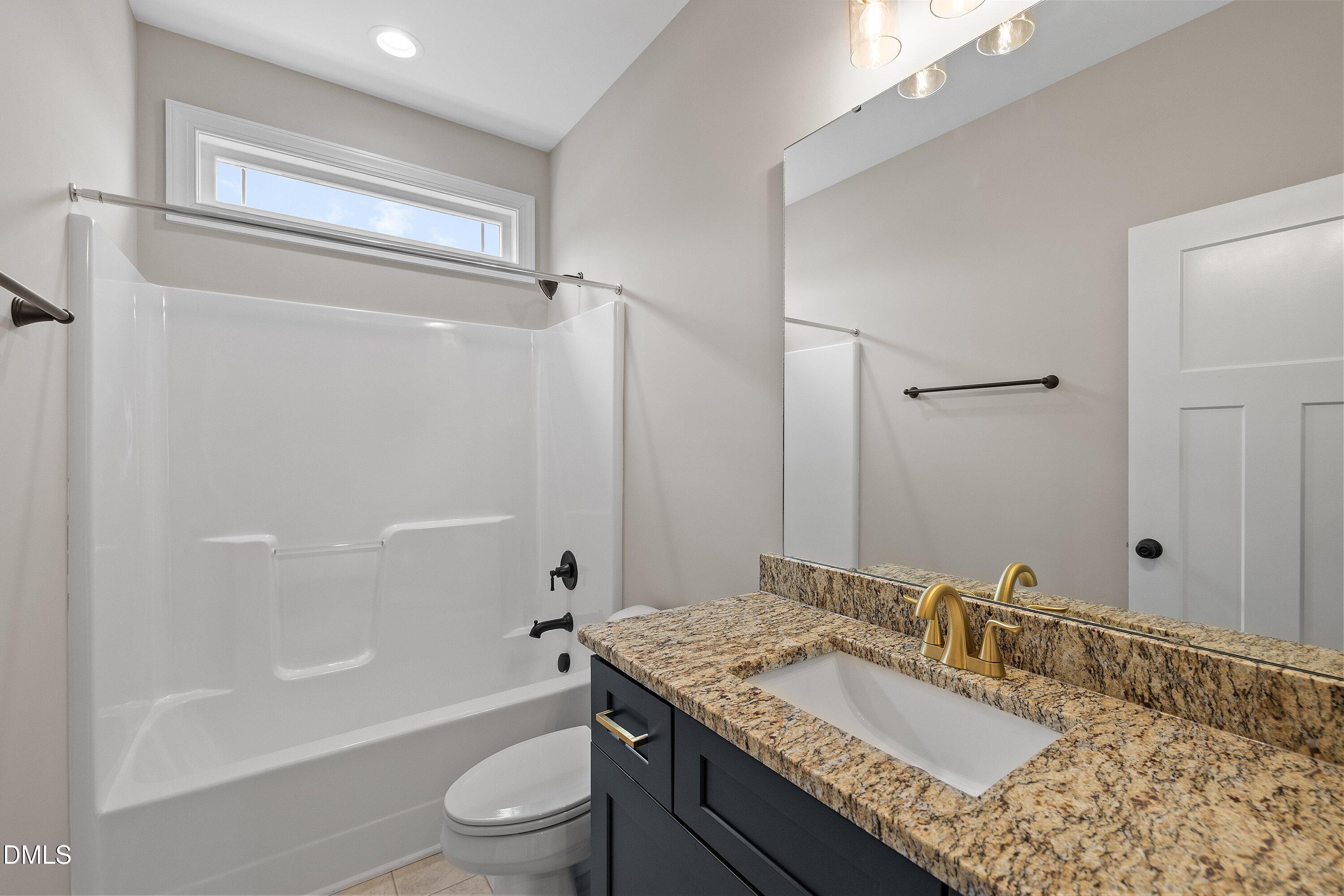 920 Micro Road West Selma, NC 27576 - Photo 25 of 34 a bathroom with a granite countertop sink a toilet and shower