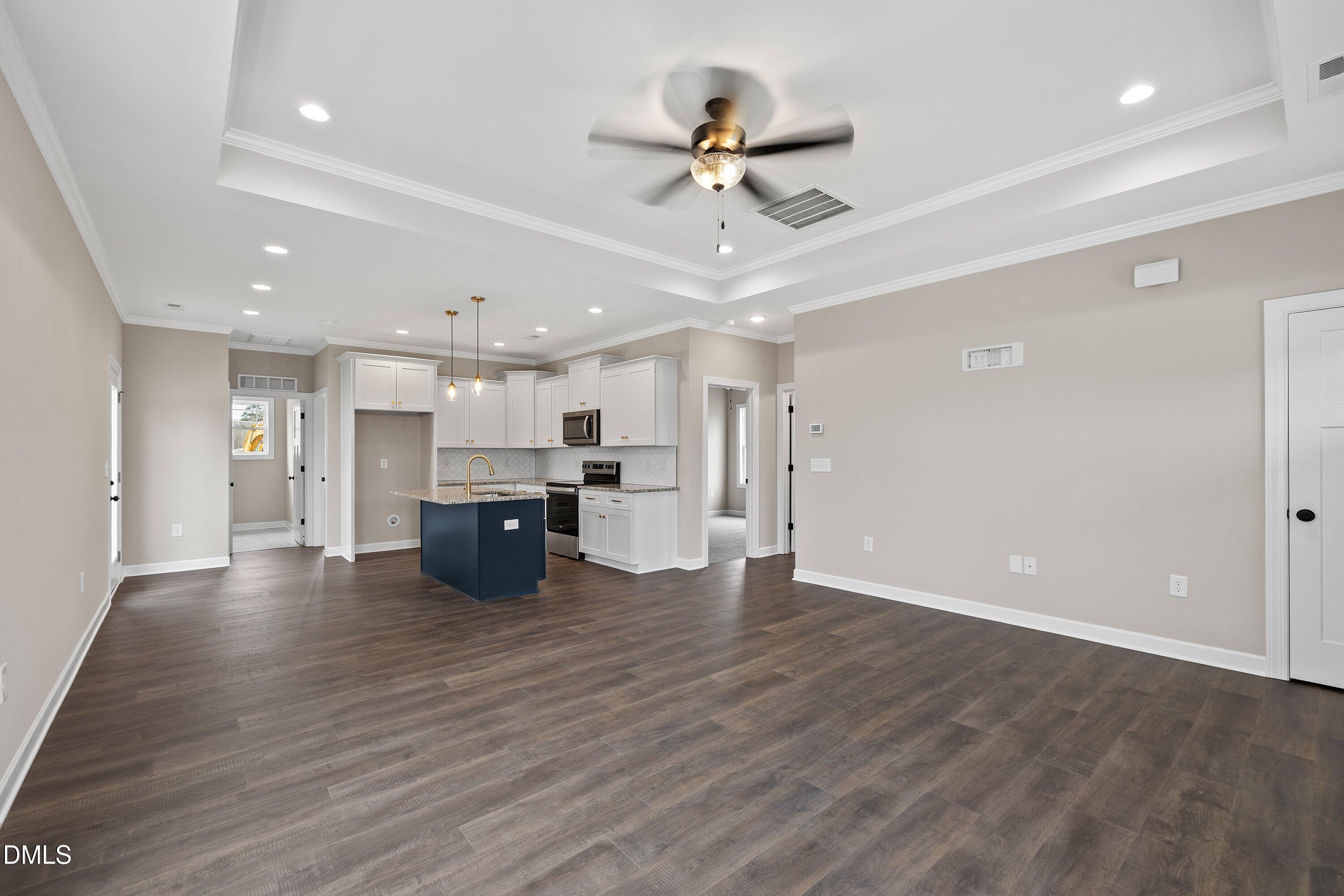 920 Micro Road West Selma, NC 27576 - Photo 7 of 32 a view of an empty room with wooden floor and a ceiling fan