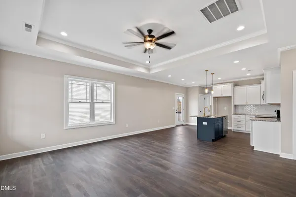 a large kitchen with granite countertop a large counter top a sink stainless steel appliances and cabinets