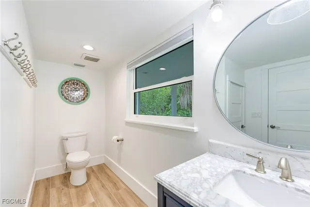 a bathroom with a toilet a sink and a mirror