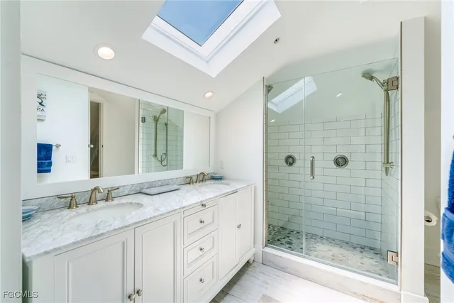a bathroom with a granite countertop double vanity sink mirror shower and double