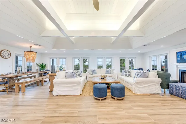 a living room with furniture large windows and wooden floor