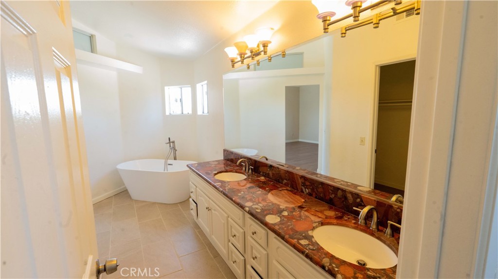 2409 Coraview Lane Rowland Heights, CA 91748 - Photo 6 of 23 a bathroom with a granite countertop double vanity sink a mirror and a bathtub