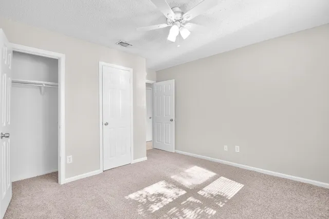 a view of a livingroom with a ceiling fan and window