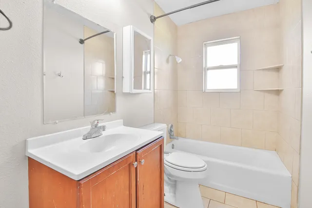 a bathroom with a sink toilet vanity and tub