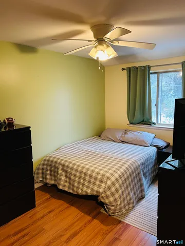 a bedroom with a bed and a flat tv screen on dresser