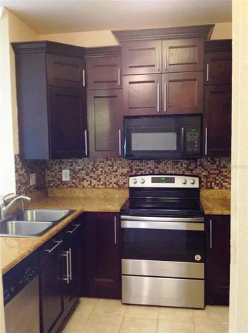 a kitchen with granite countertop a stove and a sink