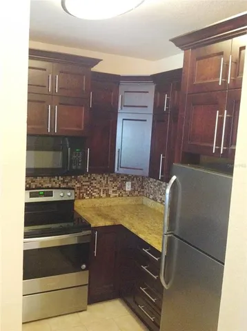 a view of kitchen with cabinets and refrigerator