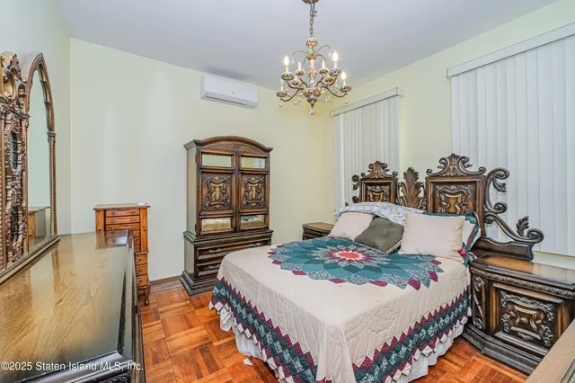 a bedroom with a bed and a chandelier