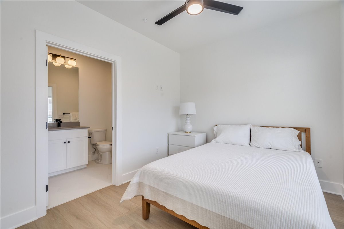 3000 Duval Street, Unit 102 Austin, TX 78705 - Photo 12 of 40 Bedroom featuring light wood-type flooring, a ceiling fan, and ensuite bathroom