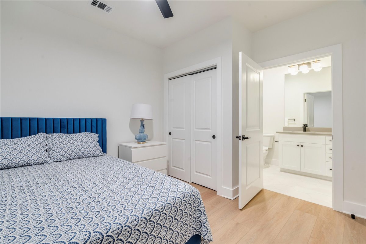 3000 Duval Street, Unit 102 Austin, TX 78705 - Photo 19 of 40 Bedroom with light wood-style floors, a closet, a ceiling fan, and ensuite bathroom