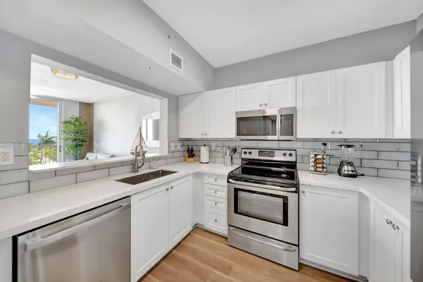 a kitchen with refrigerator and cabinets