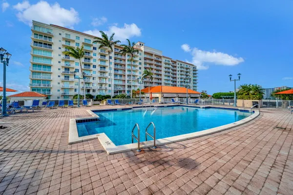 a view of a swimming pool with outdoor seating and plants