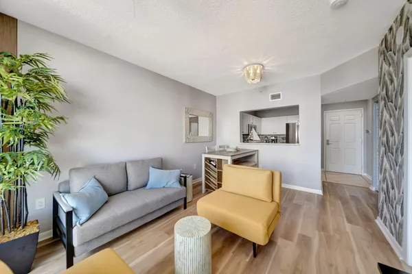 a living room with furniture and a wooden floor
