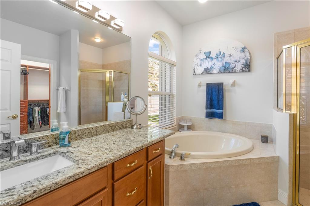 4923 Cerromar Drive Naples, FL 34112 - Photo 18 of 39 a bathroom with a granite countertop tub sink and mirror