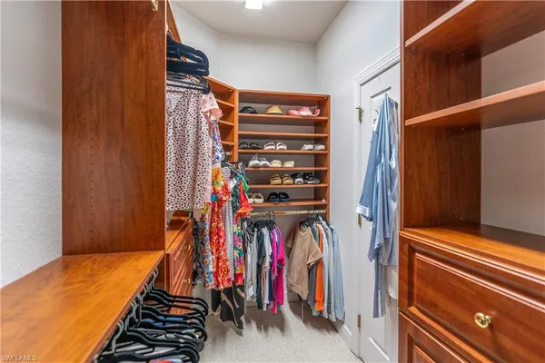 a view of walk in closet with clothes
