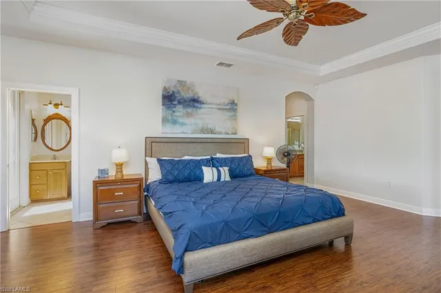 a bedroom with a bed and dresser with wooden floor