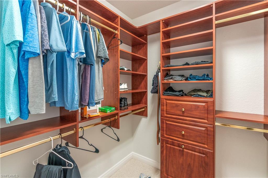 4923 Cerromar Drive Naples, FL 34112 - Photo 22 of 39 a view of walk in closet with clothes and shoes