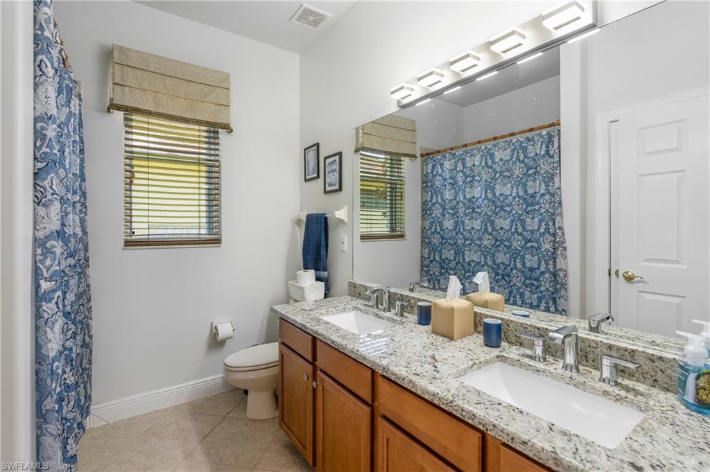 4923 Cerromar Drive Naples, FL 34112 - Photo 24 of 39 a bathroom with a granite countertop sink toilet and shower