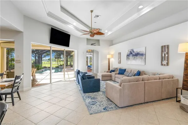 a living room with furniture a flat screen tv and a chandelier