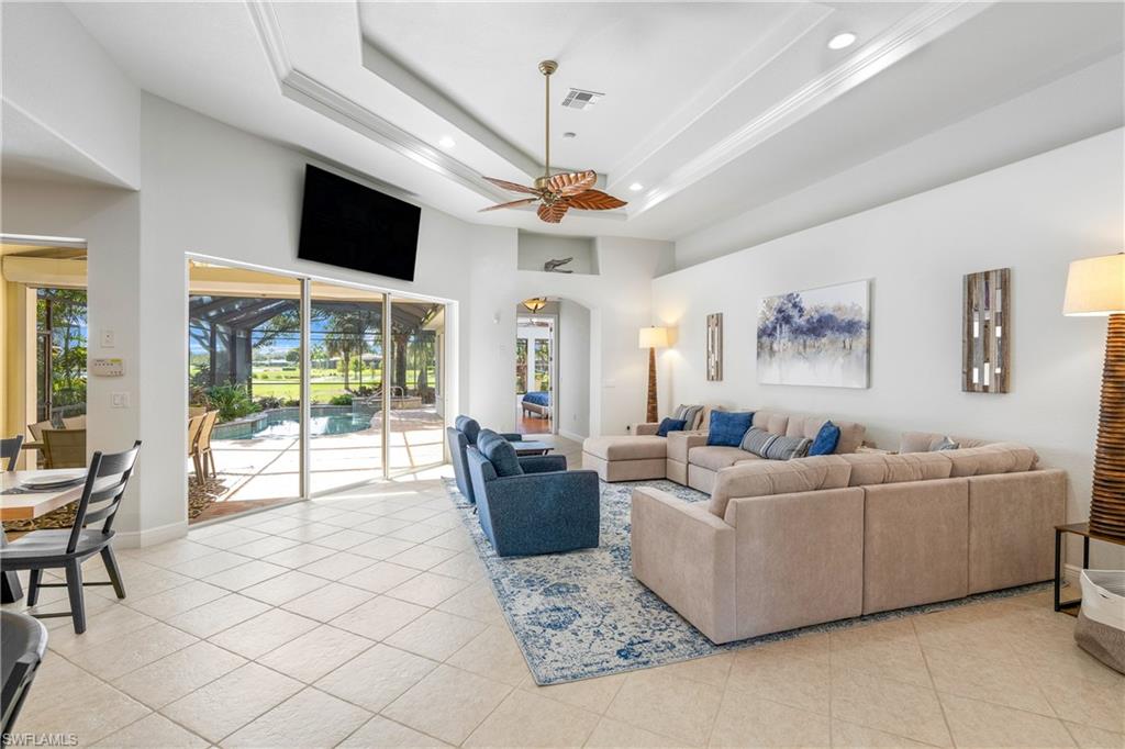 4923 Cerromar Drive Naples, FL 34112 - Photo 5 of 39 a living room with furniture a flat screen tv and a chandelier