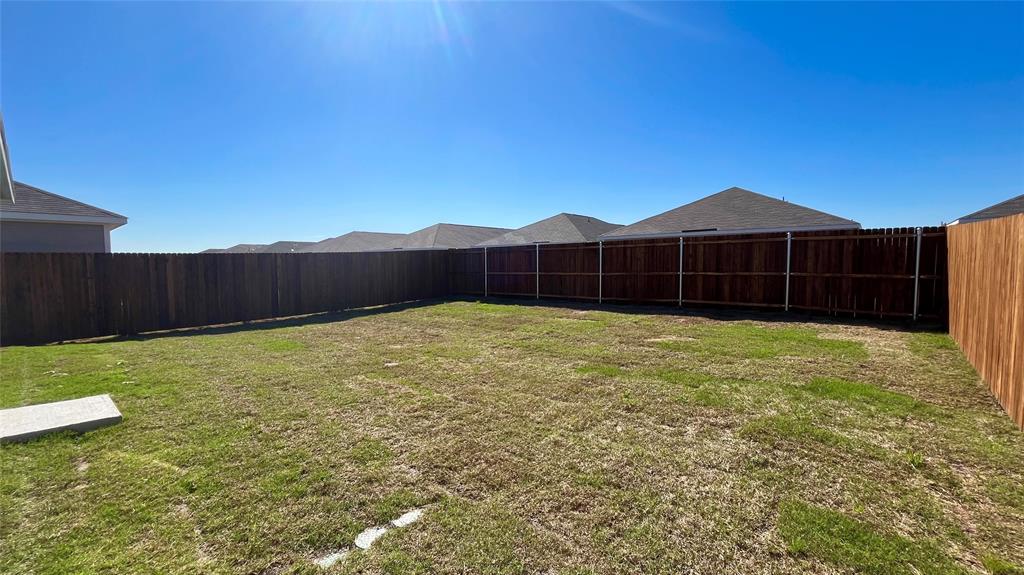 403 Ashbrook Way Princeton, TX 75407 - Photo 22 of 23 Spacious backyard featuring a full perimeter privacy fence and a concrete pad