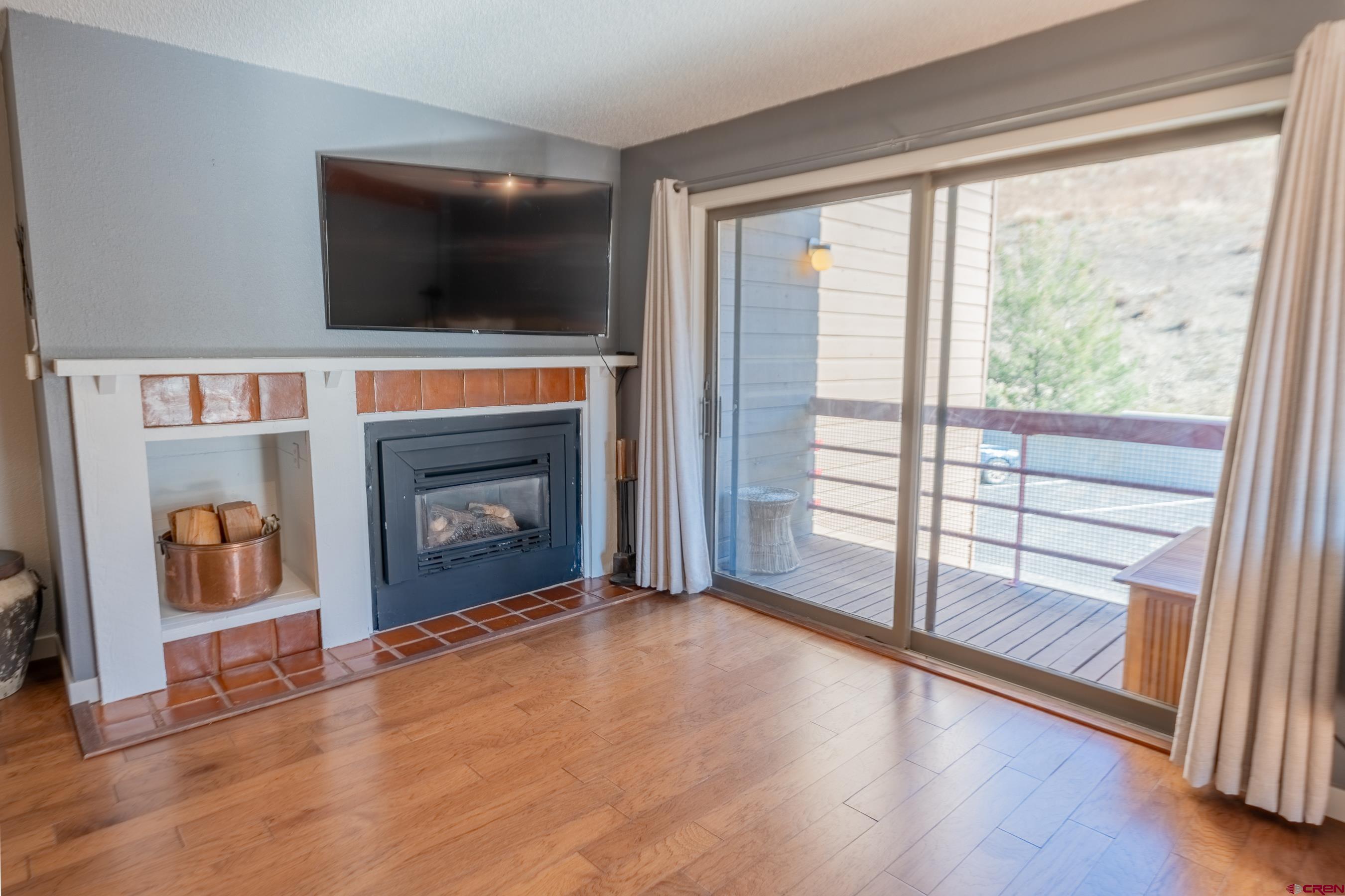 25 Emmons Road, Unit 37 Crested Butte, CO 81225 - Photo 16 of 35 a living room with a fireplace and a flat screen tv