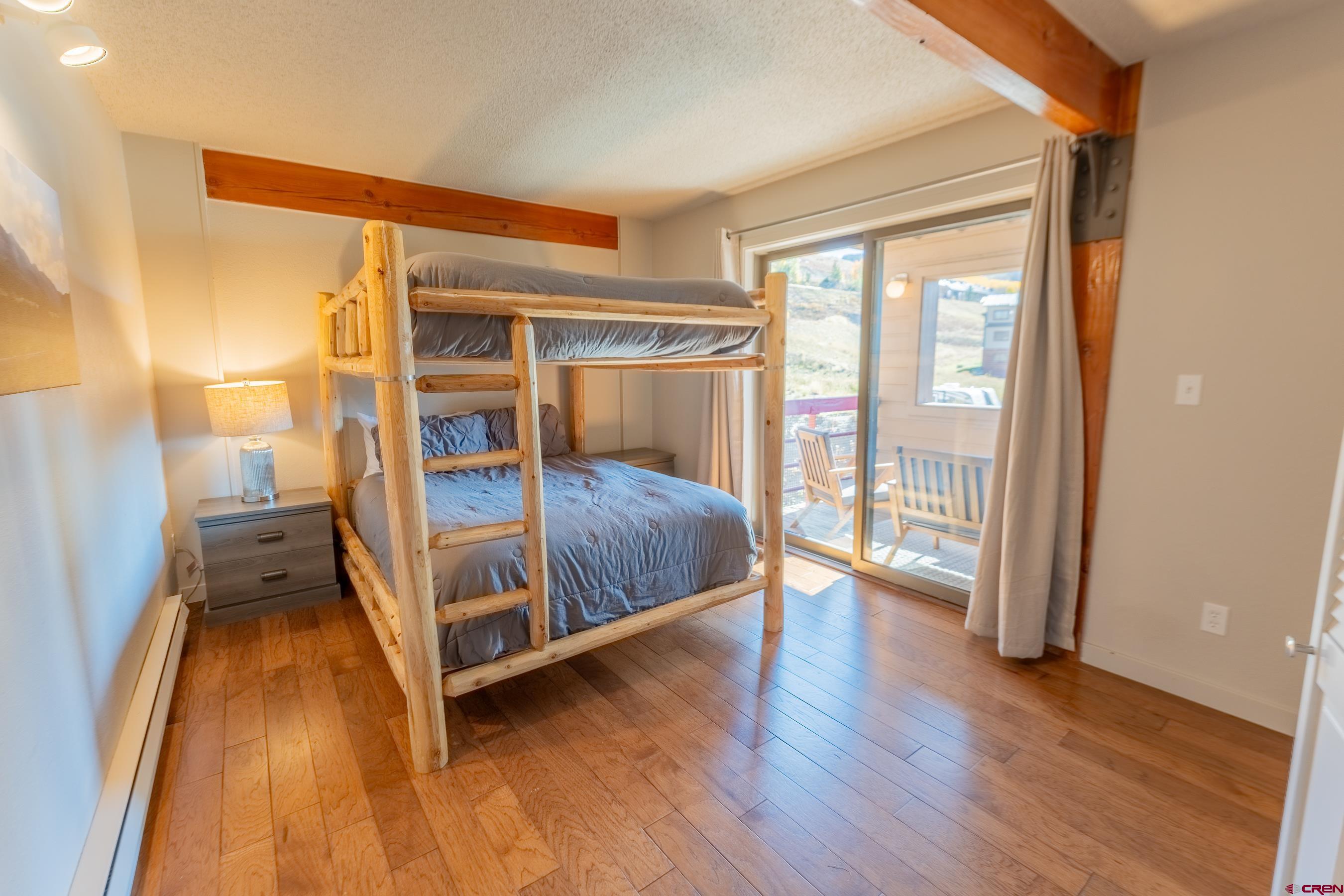25 Emmons Road, Unit 37 Crested Butte, CO 81225 - Photo 24 of 35 a bedroom with a bed and wooden floor