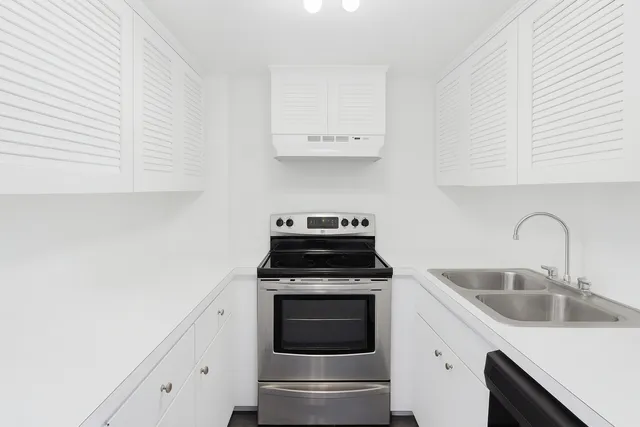 a kitchen with cabinets a stove and a sink