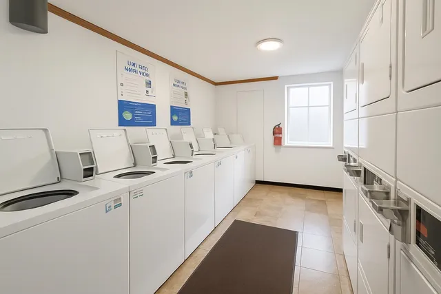 a view of a kitchen with refrigerator and white cabinets