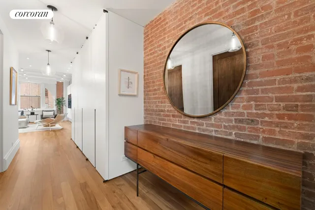 a view of a living room and bathroom with a wooden floor