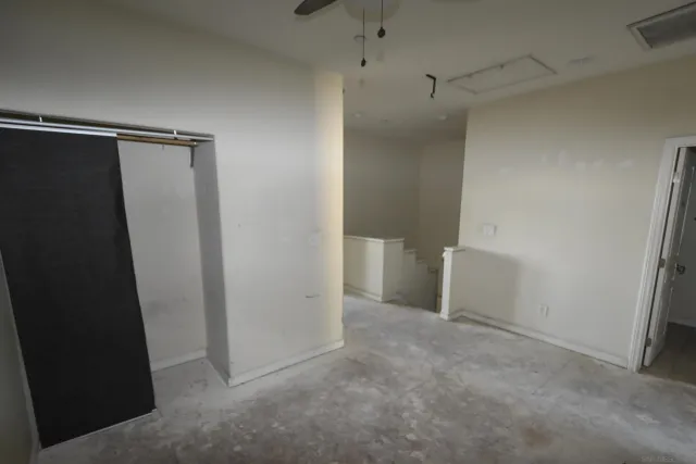 an empty room with a window and a fan