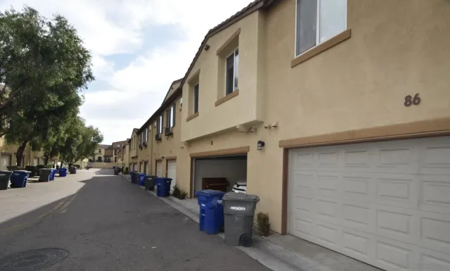 a view of a house with a big yard and potted plants