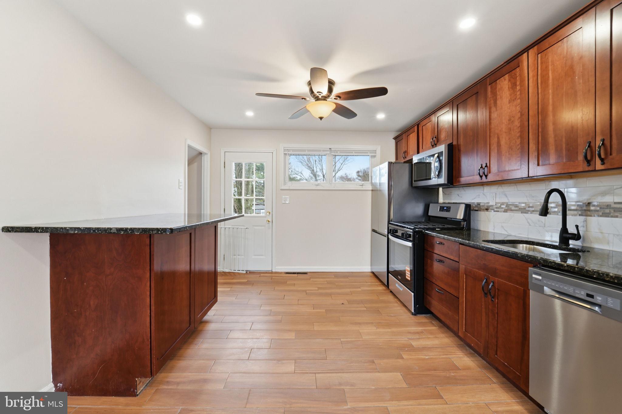 490 Hamilton Road Wenonah, NJ 08090 - Photo 18 of 49 a kitchen with kitchen island granite countertop wooden cabinets a sink a stove a refrigerator and island