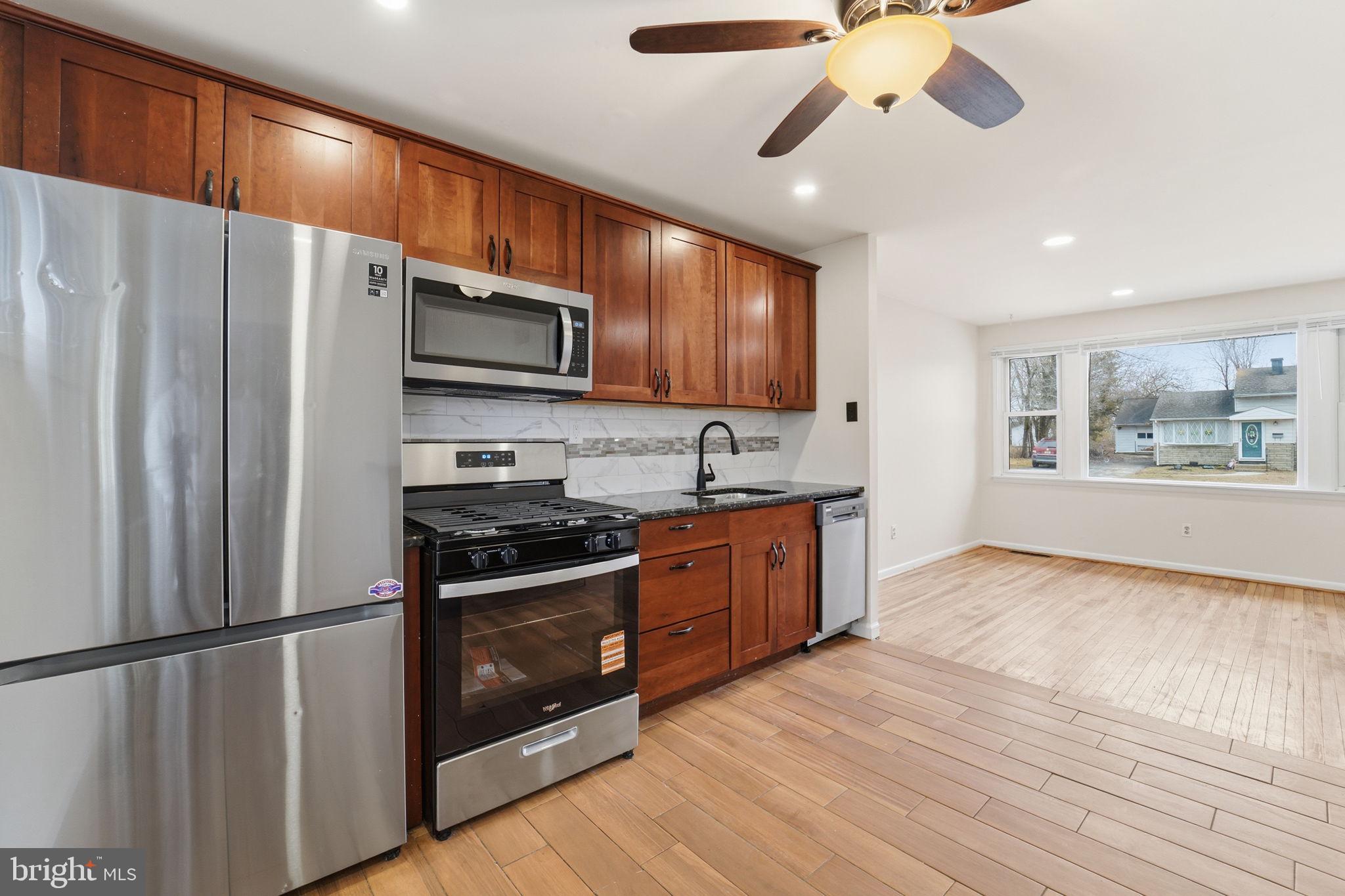 490 Hamilton Road Wenonah, NJ 08090 - Photo 19 of 49 a kitchen with stainless steel appliances granite countertop a refrigerator a stove a sink dishwasher and a microwave oven with cabinets