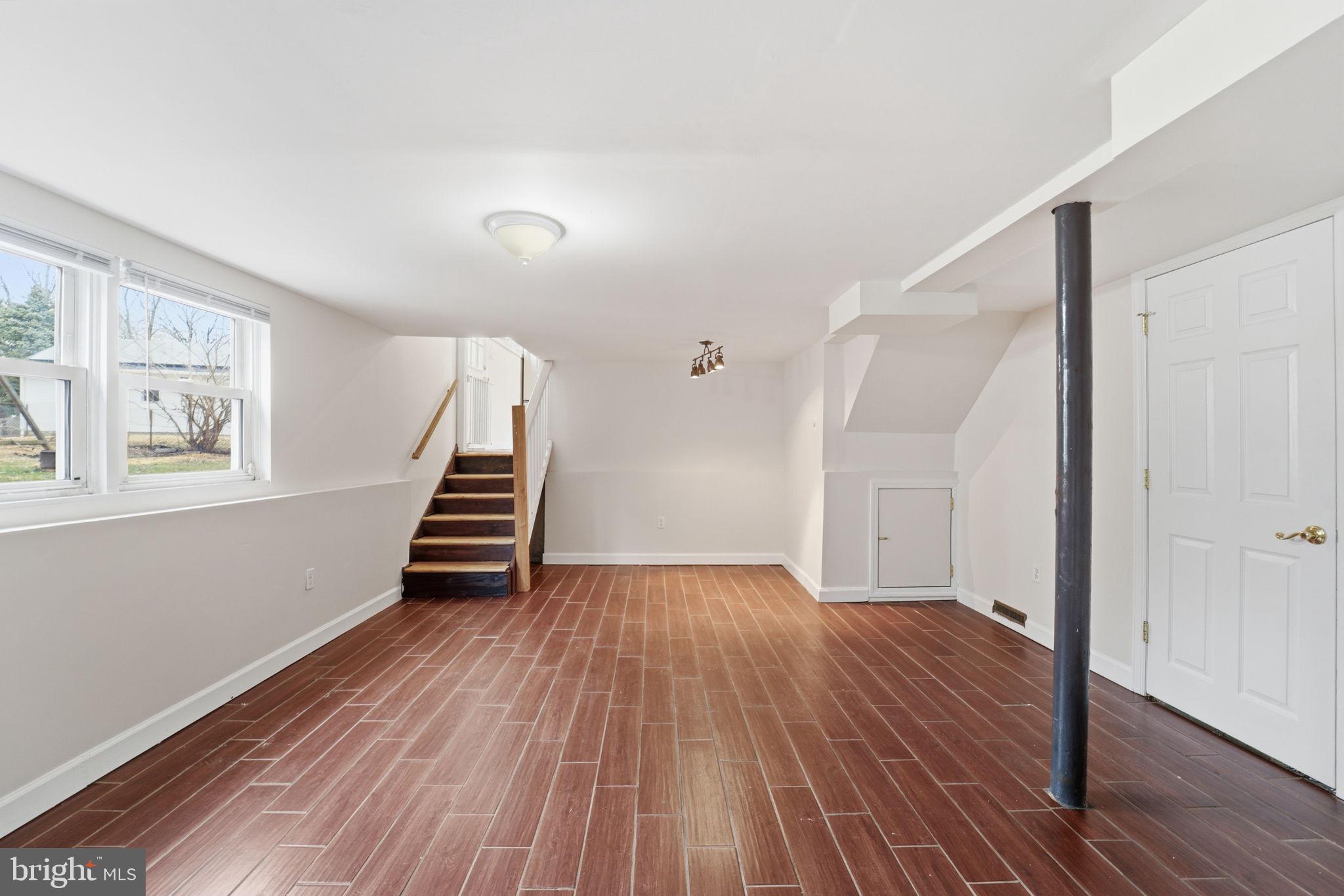 490 Hamilton Road Wenonah, NJ 08090 - Photo 23 of 49 a view of an empty room with wooden floor and stairs